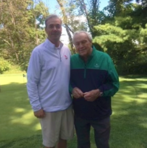 Joe Farrell stands next to golf legend Arnold Palmer